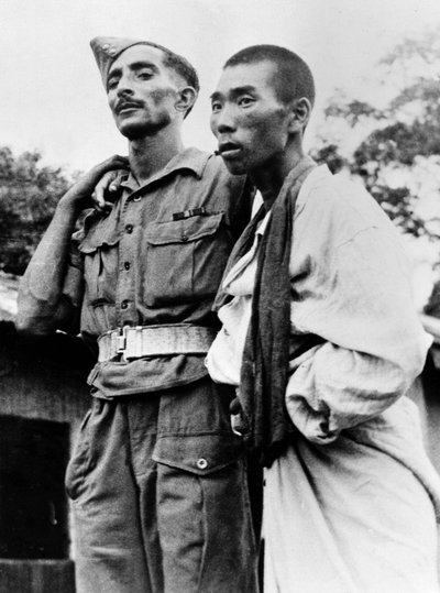 An Indian Army medic helping a wounded Japanese prisoner of war, 1945 by English Photographer